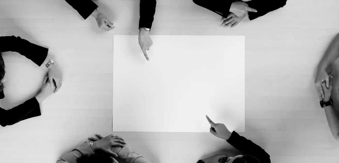 Executives in discussion around a boardroom table, seen from above