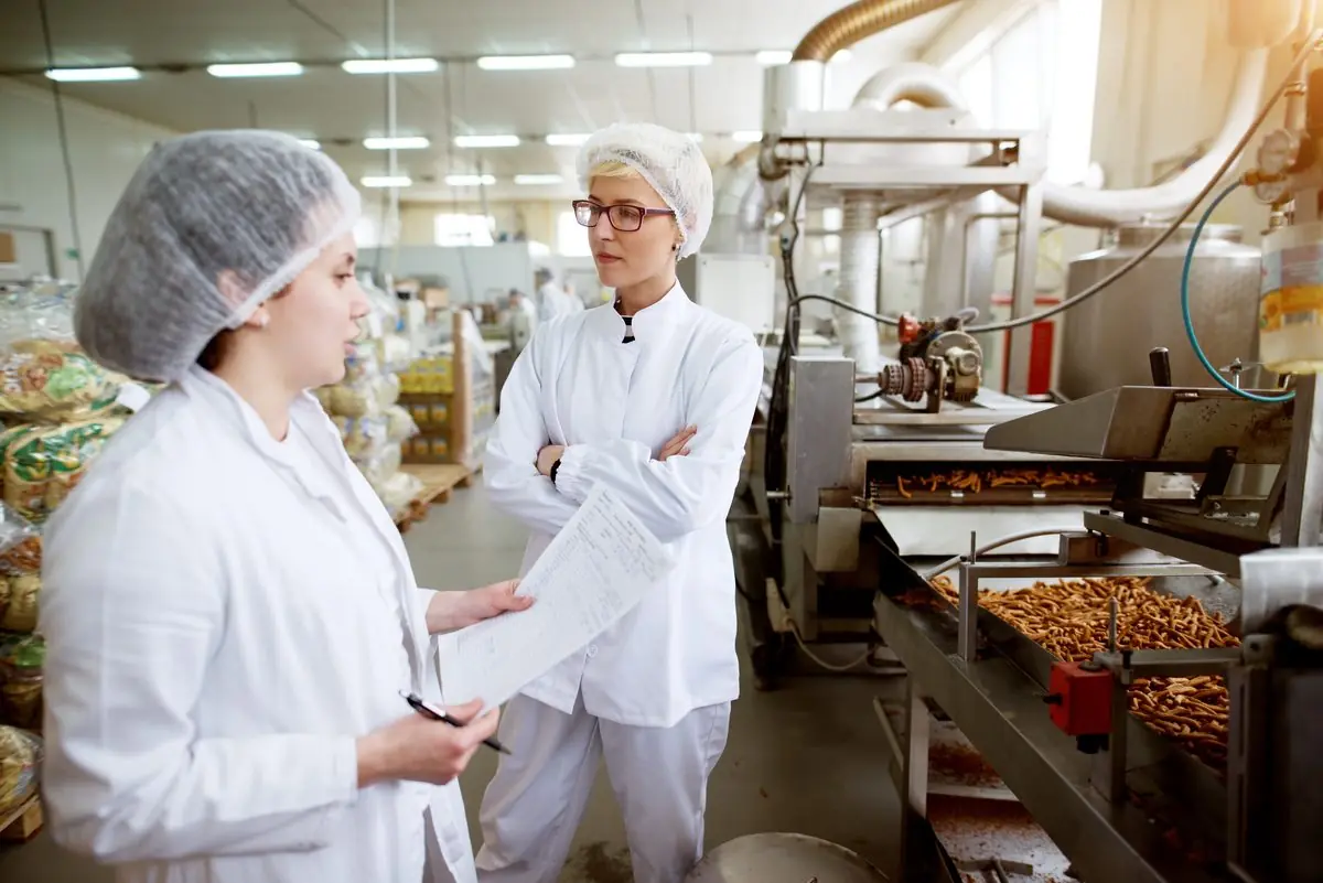 Production supervisor checking output on a food manufacturing line