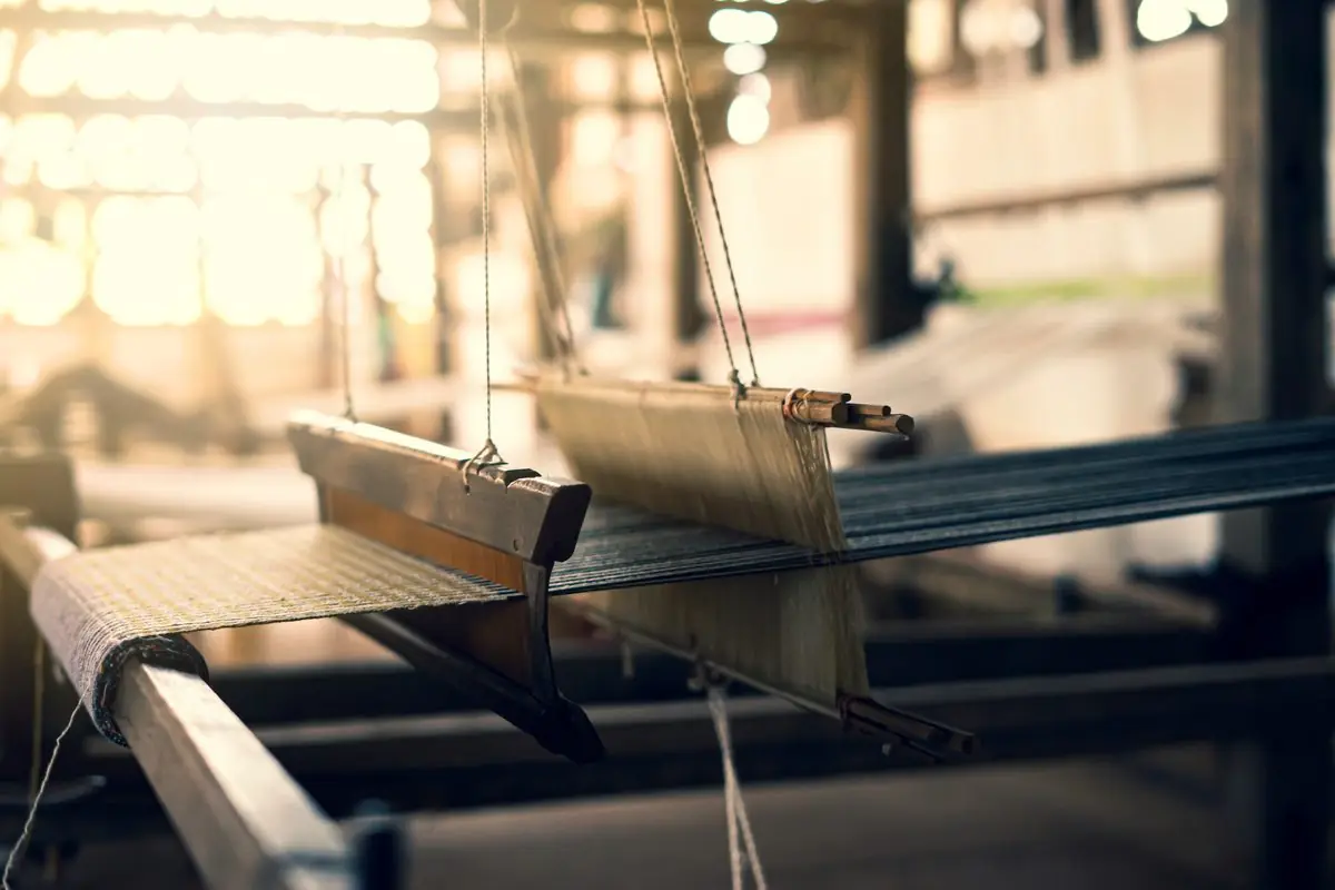 Artisan weaving on a traditional handloom in a South Asian workshop